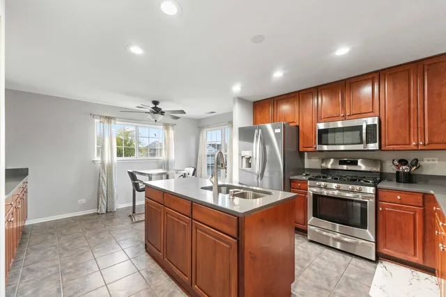 a kitchen with stainless steel appliances granite countertop a sink stove and refrigerator