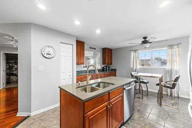a kitchen that has a sink a stove and chairs