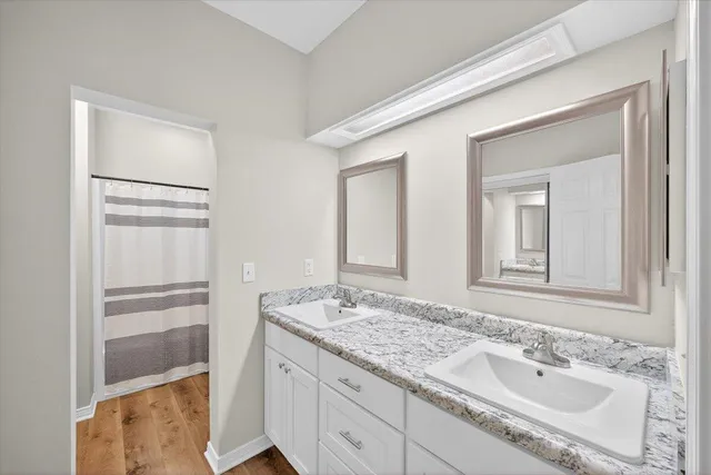 a bathroom with a granite countertop sink and a mirror