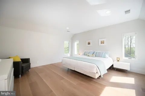 a bedroom with a bed and a lamp on dresser