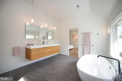 a bathroom with a tub sink and mirror