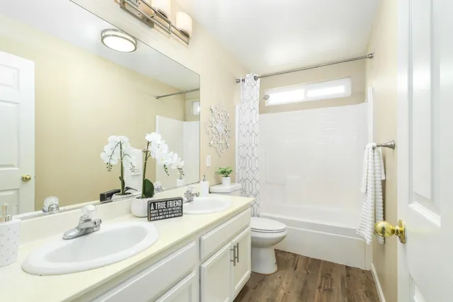 a bathroom with a sink a toilet and shower