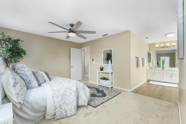 a spacious bedroom with a bed and ceiling fan