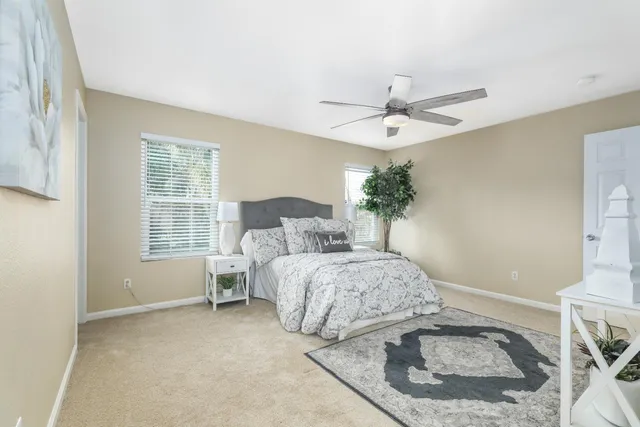 a spacious bedroom with a bed and a chandelier
