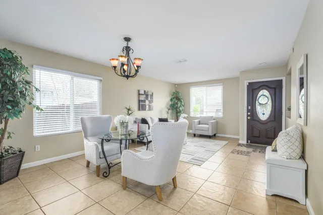 a living room with couches a large mirror and a dining table with a large window