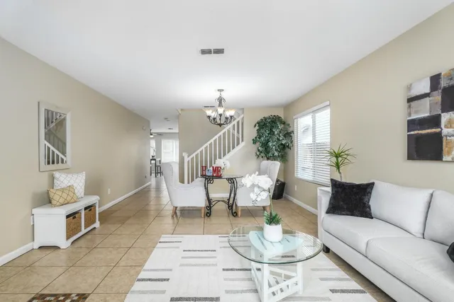 a living room with furniture and a dining table with rug