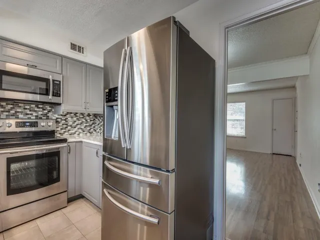 a kitchen with stainless steel appliances granite countertop a refrigerator and a stove top oven