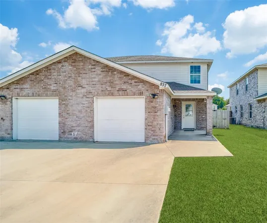 a view of yellow house with a yard and a garage