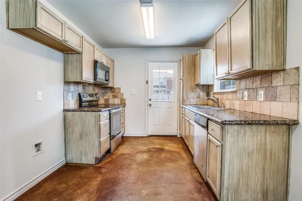 a kitchen with stainless steel appliances granite countertop a stove a sink and a refrigerator