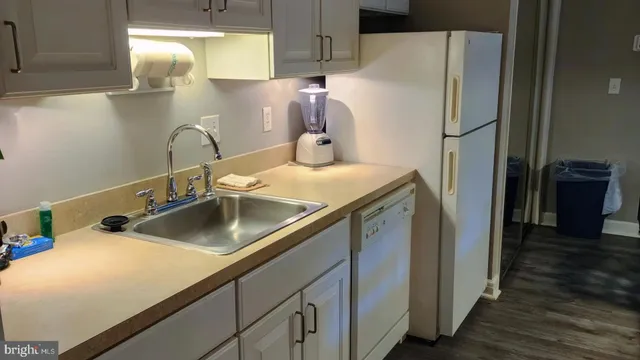 a kitchen with stainless steel appliances kitchen island a refrigerator sink and cabinets