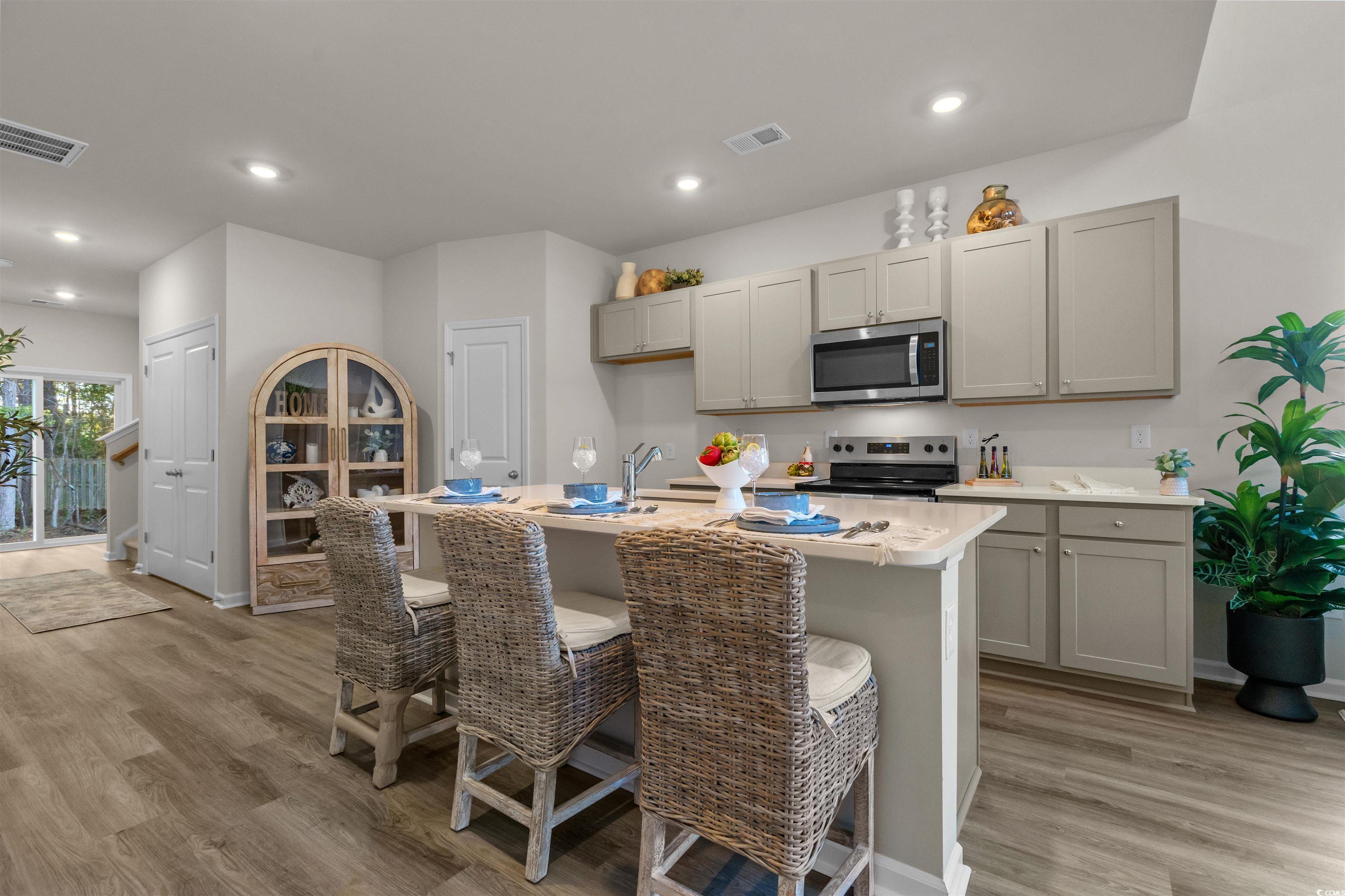 816 Palm Frond Way, Unit 41 Calabash, NC 28467 - Photo 14 of 35 Kitchen featuring gray cabinets, stainless steel appliances, a center island with sink, light wood-type flooring, and recessed lighting