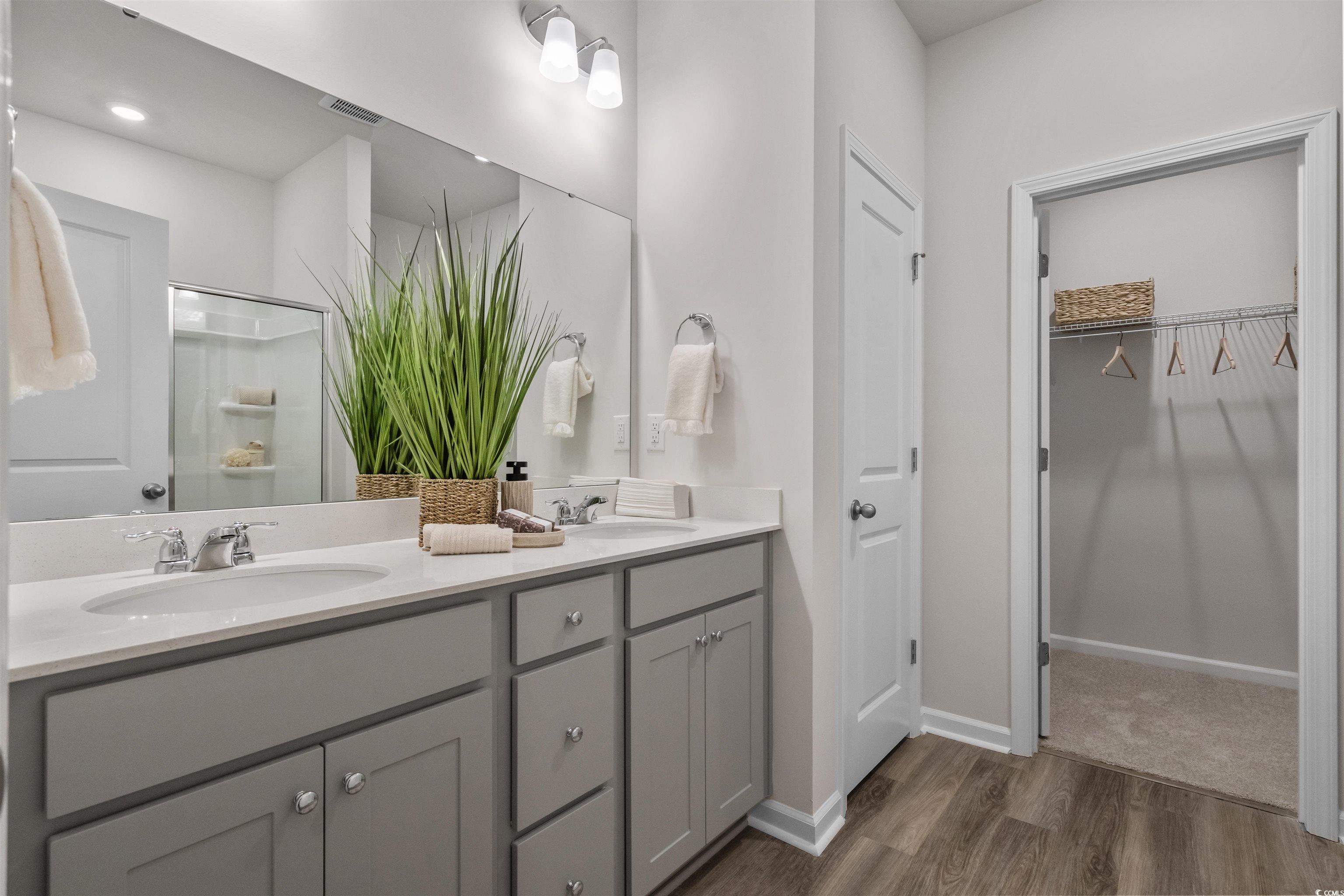 816 Palm Frond Way, Unit 41 Calabash, NC 28467 - Photo 20 of 35 Bathroom featuring a shower stall, 36" double vanity, a walk in closet, and LVP flooring, representative photo from furnished model