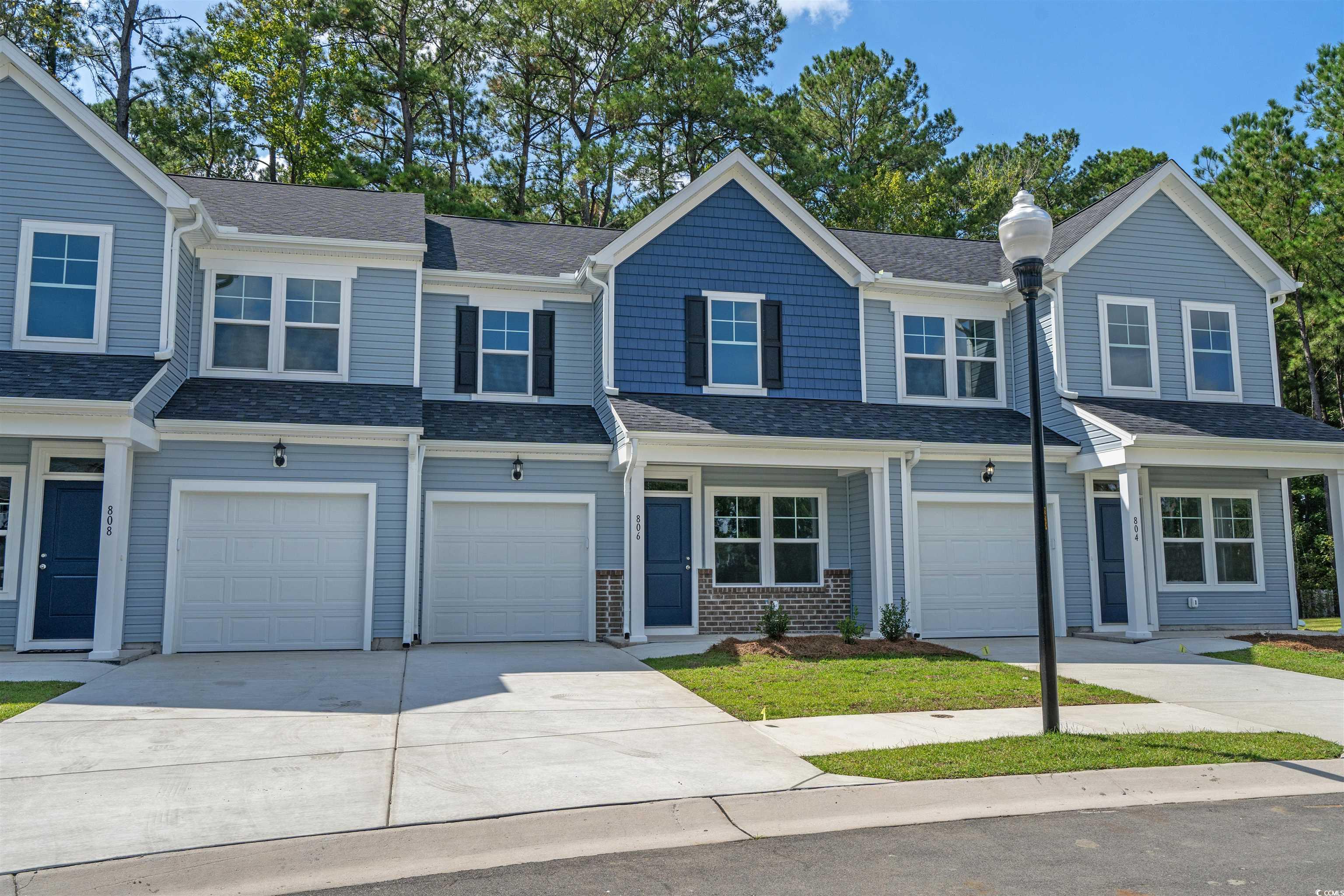 816 Palm Frond Way, Unit 41 Calabash, NC 28467 - Photo 32 of 35 View of front of home with driveway, a garage, a shingled roof, and covered porch
