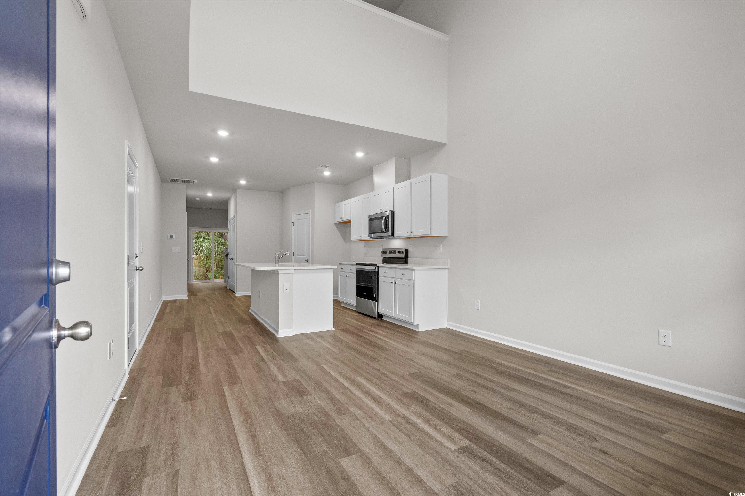 816 Palm Frond Way, Unit 41 Calabash, NC 28467 - Photo 10 of 35 Kitchen with a kitchen island with sink, white cabinets, stainless steel appliances, recessed lighting, and LVP finished floors