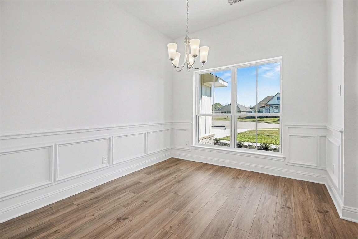 8 Gemstone Court Angleton, TX 77515 - Photo 5 of 7 a view of an empty room with wooden floor and window