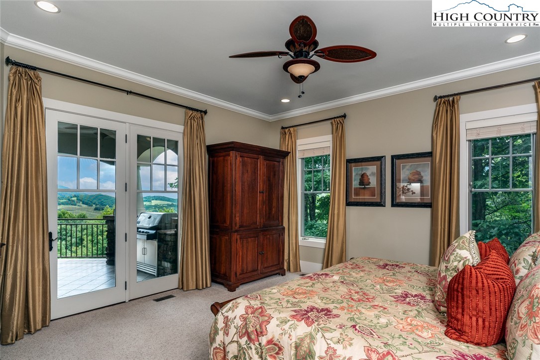 879 Winding Ridge Drive West Jefferson, NC 28694 - Photo 16 of 37 a bedroom with a large bed and a chandelier