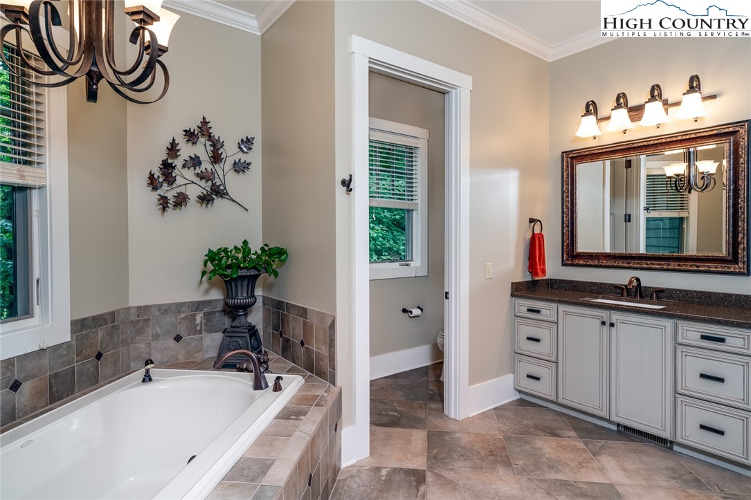 879 Winding Ridge Drive West Jefferson, NC 28694 - Photo 18 of 37 a bathroom with a tub sink and mirror