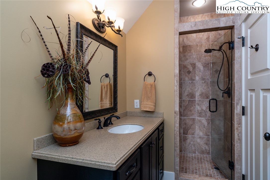 879 Winding Ridge Drive West Jefferson, NC 28694 - Photo 24 of 37 a bathroom with a sink a mirror and shower