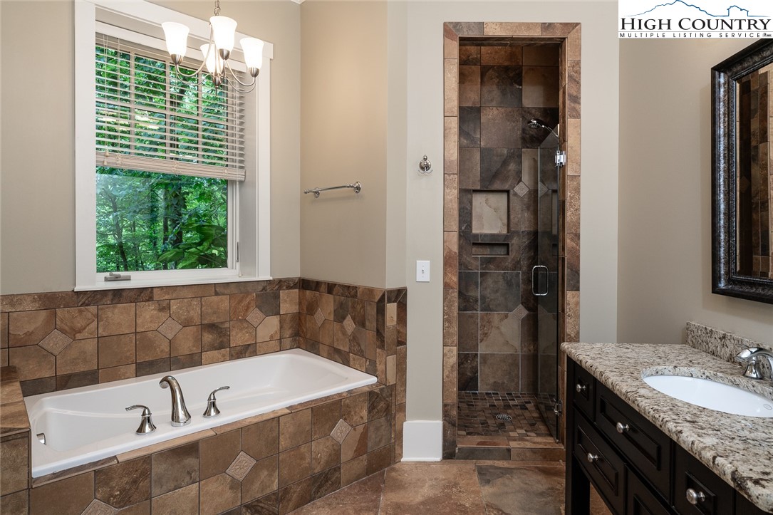 879 Winding Ridge Drive West Jefferson, NC 28694 - Photo 26 of 37 a bathroom with a tub a sink and a window