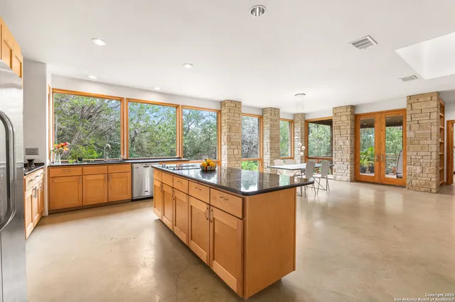 a large kitchen with kitchen island a large window and a sink