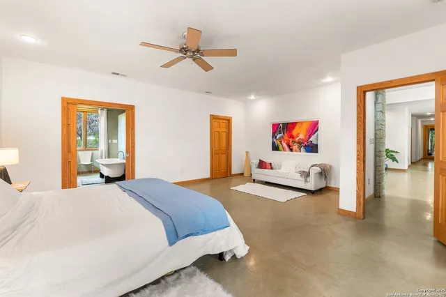 a spacious bedroom with a bed dresser and a window