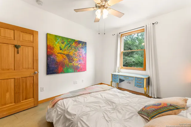 a bedroom with a bed and a painting on the wall