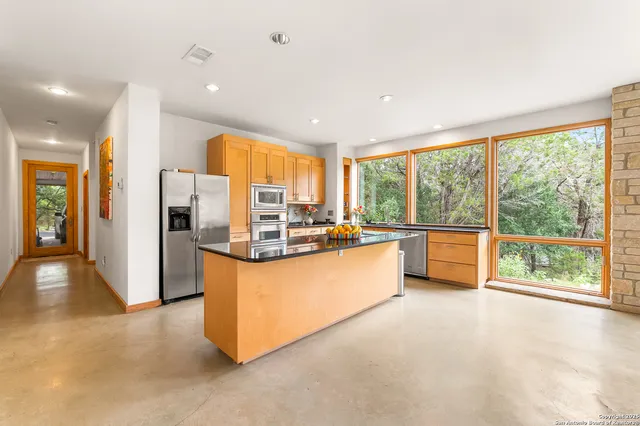 a view of kitchen with kitchen island wooden floor and stainless steel appliances