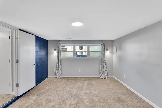 an empty room with closet and windows