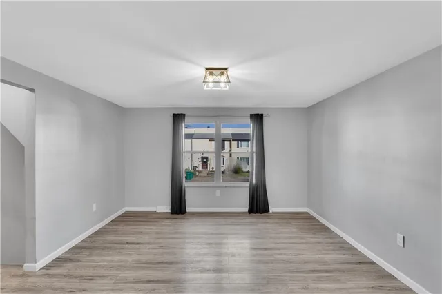 a view of a kitchen with wooden floor and a window