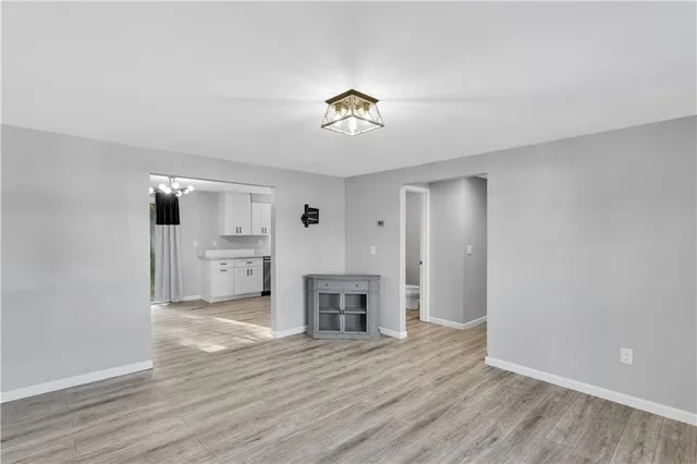 a view of a livingroom with a fireplace a chandelier and wooden floor
