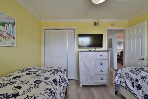 a bedroom with a bed and a flat tv screen on dresser