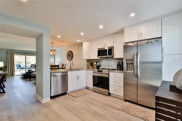 a kitchen with a refrigerator cabinets and wooden floor