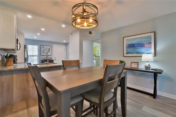 a dining room with wooden floor and a chandelier