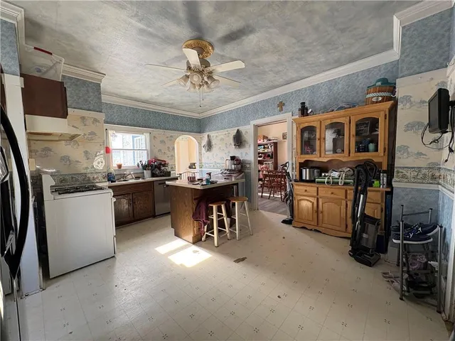 a kitchen with stainless steel appliances kitchen island granite countertop a stove top oven a sink a dining table and chairs