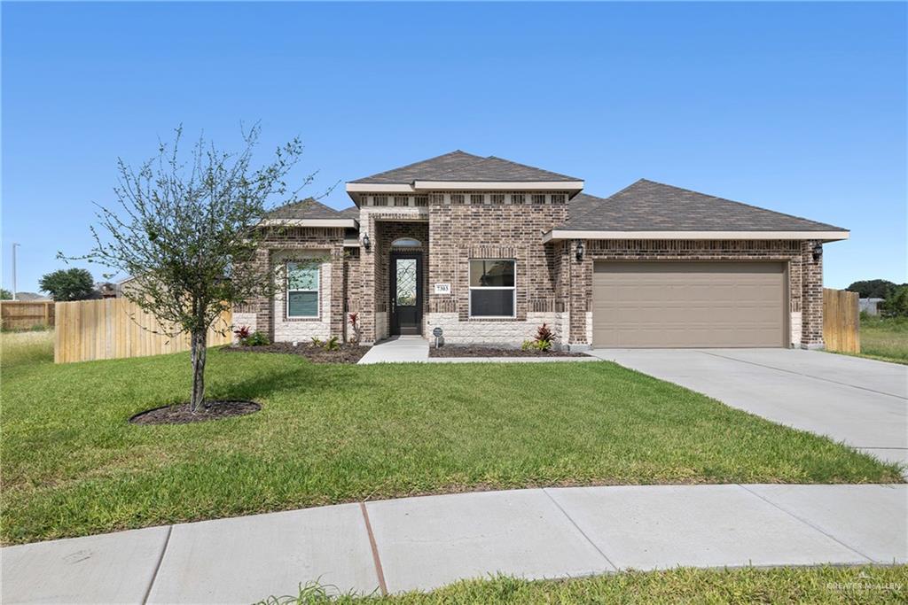 7303 Umar Avenue Mission, TX 78573 - Photo 1 of 1 View of front of home featuring an attached garage, driveway, brick siding, and a shingled roof