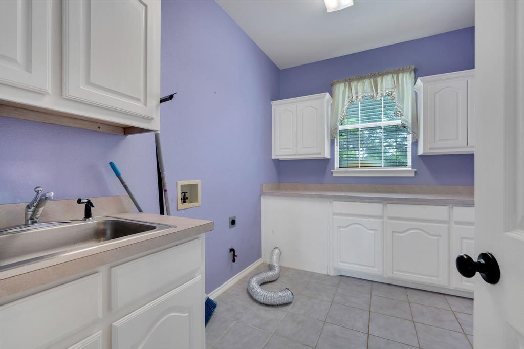 1907 Timber Ridge Court Cedar Hill, TX 75104 - Photo 25 of 30 Utility room featuring white cabinetry, a stainless steel sink with an integrated faucet, light-colored countertops, and a window