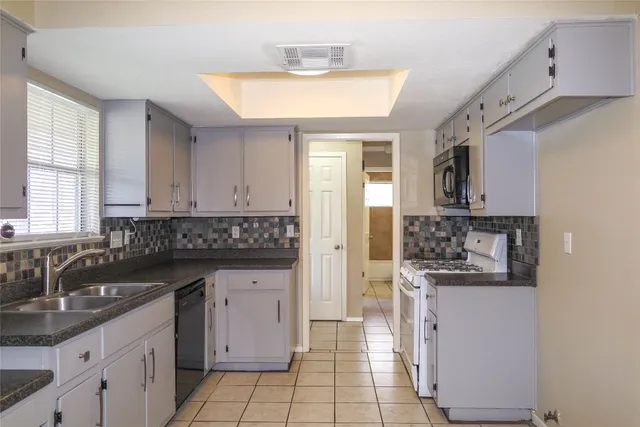 a kitchen with granite countertop a sink and cabinets