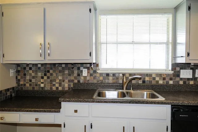 a kitchen with granite countertop a sink and a stove