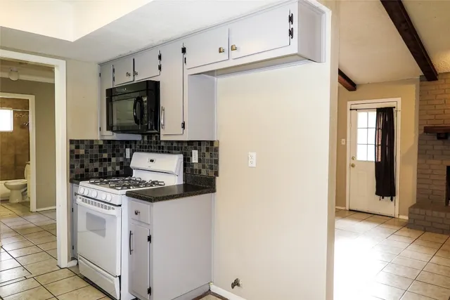 a kitchen with white cabinets and white appliances
