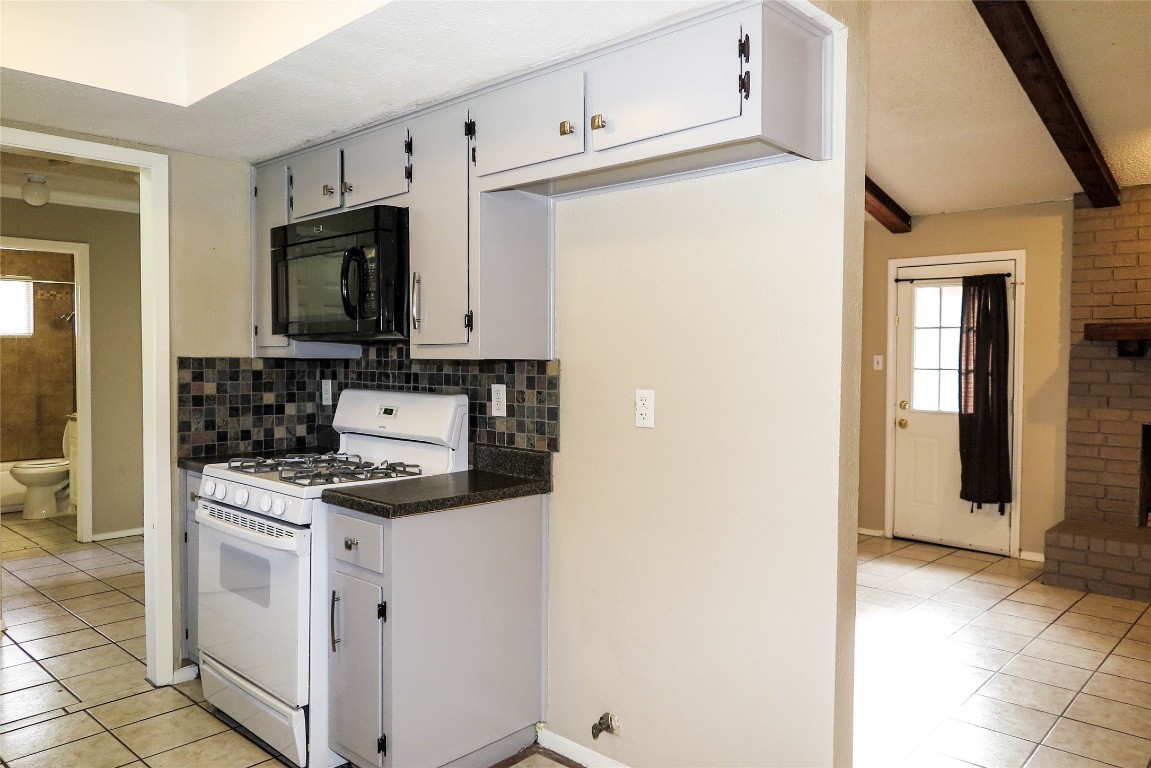 308 Golden Oaks Drive Georgetown, TX 78628 - Photo 7 of 25 a kitchen with white cabinets and white appliances