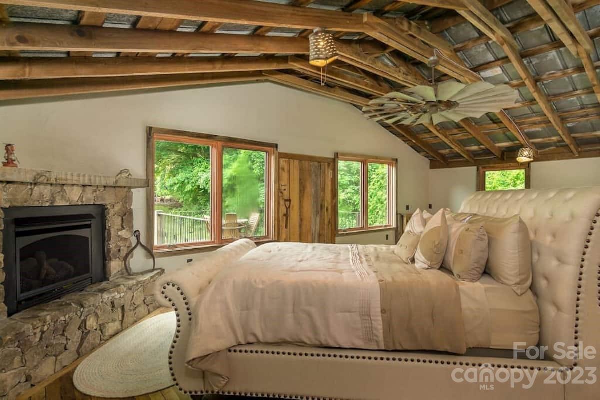 72 Scotchmans Road Waynesville, NC 28786 - Photo 19 of 46 a bedroom with a bed and a fireplace