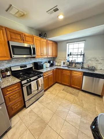 a kitchen with stainless steel appliances granite countertop a sink and cabinets