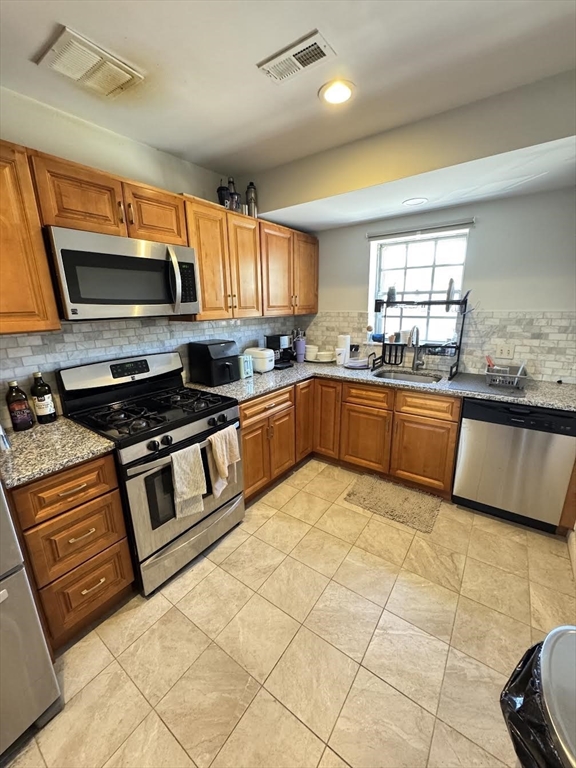 a kitchen with stainless steel appliances granite countertop a sink and cabinets