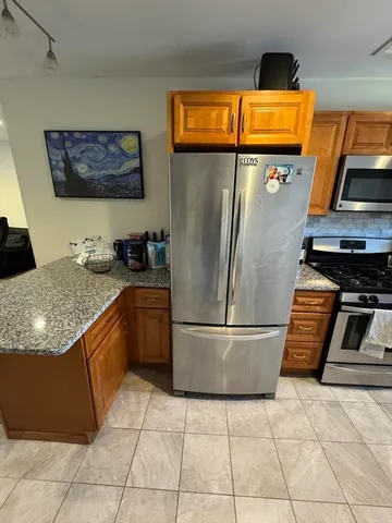 a kitchen with stainless steel appliances granite countertop a refrigerator and a stove