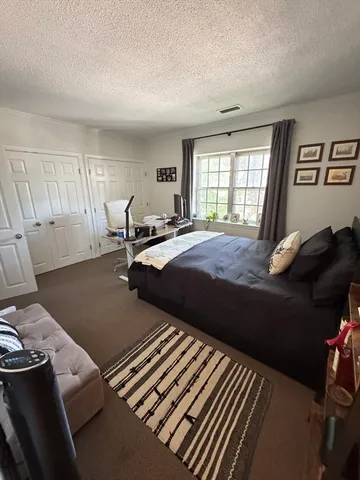 a bed sitting in a bedroom next to a window