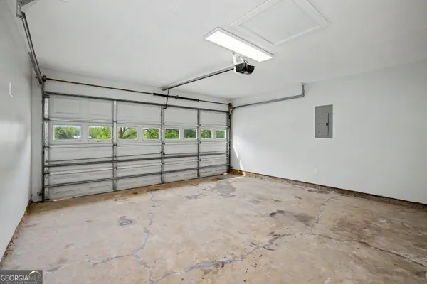 a view of an empty room with a chandelier fan