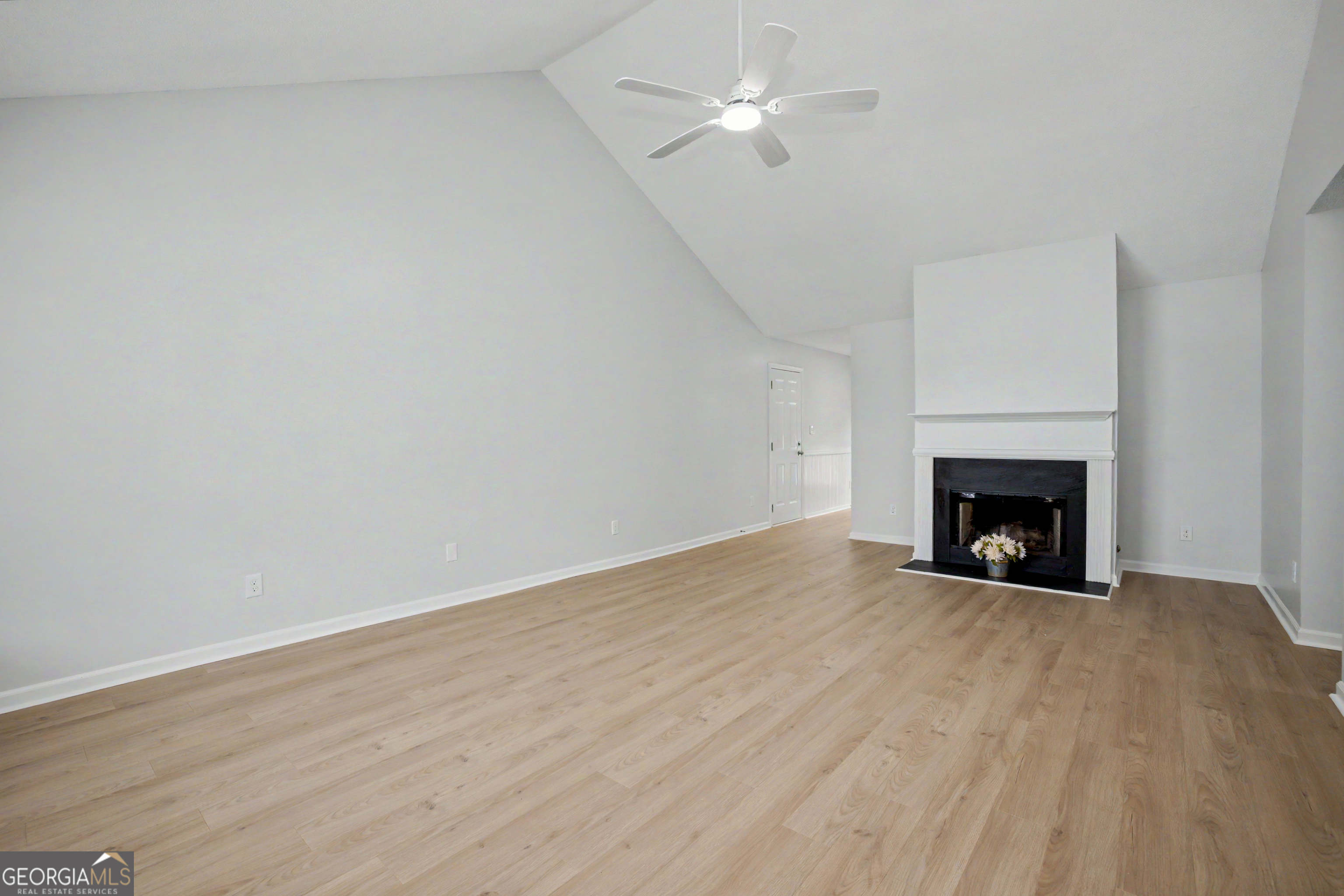 613 Coan Drive Locust Grove, GA 30248 - Photo 10 of 34 a view of an empty room with wooden floor fireplace and a window