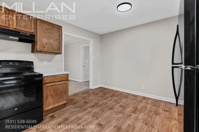 a kitchen with a refrigerator and a stove top oven