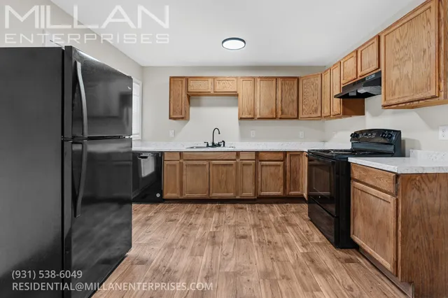 a kitchen with stainless steel appliances granite countertop a refrigerator a sink dishwasher a stove with wooden cabinets and floor