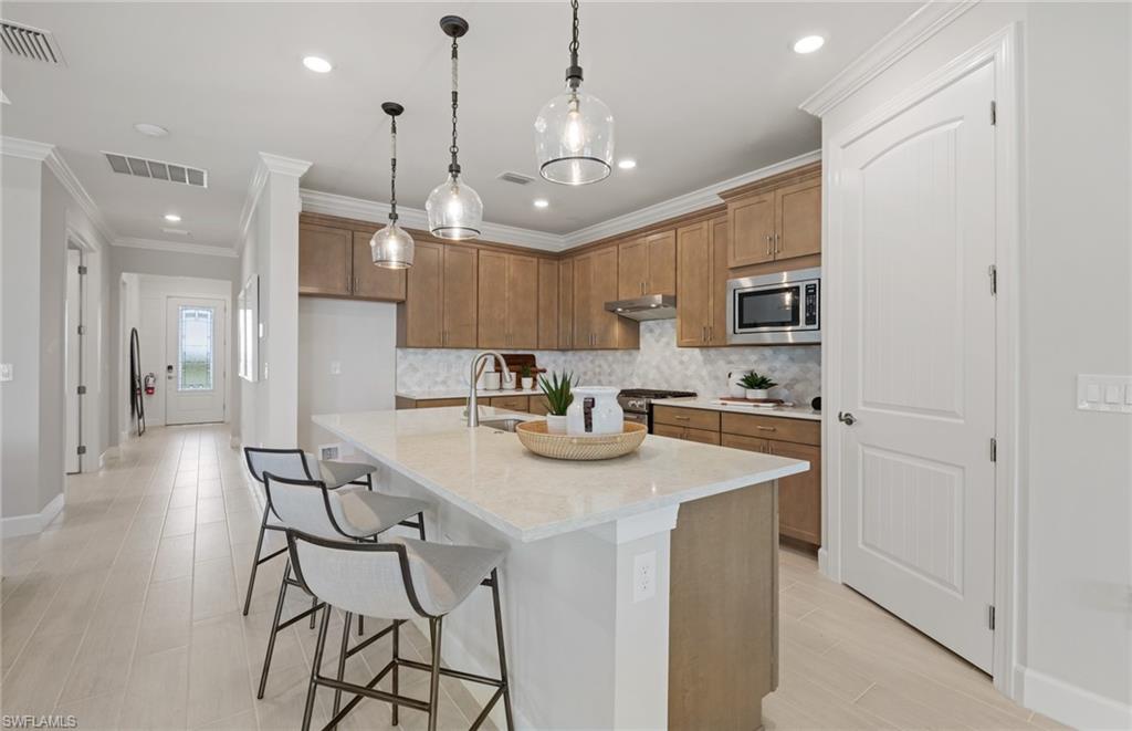20322 Napa Loop Estero, FL 33928 - Photo 29 of 46 a kitchen with stainless steel appliances granite countertop a sink a stove a refrigerator and island with wooden floor